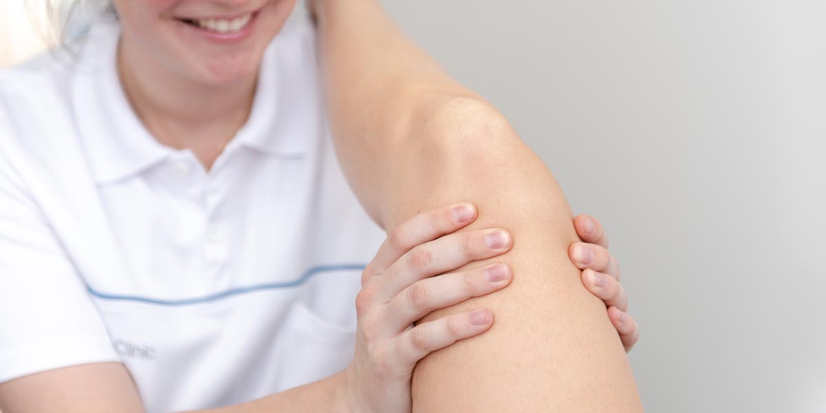 Physio behandelt Knie einer Patientin