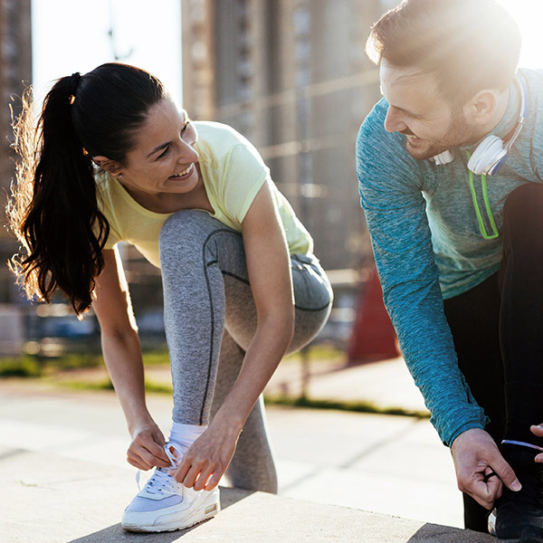 Frau und Mann schnüren Joggingschuhe