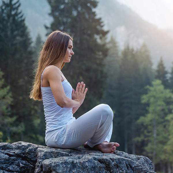 Frau im Yogasitz im Freien